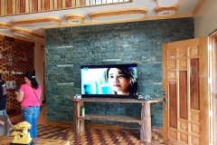 wide screen TV but wider expanse of green stones